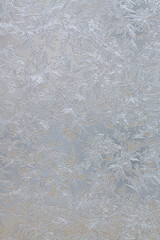 Frozen drops of condensed steam water drops on the transparent window glass. Clean blue background. Condensation of moisture at extreme temperatures. Beautiful nature texture