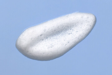 Foam lather texture background. White cleanser gel, shaving foam, shampoo bubbles on blue	
