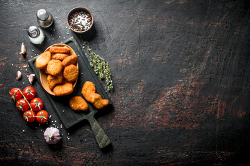 Chicken nuggets with cherry tomatoes, spices and garlic cloves.