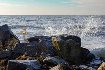 a beautiful seashore with a wave and big stones