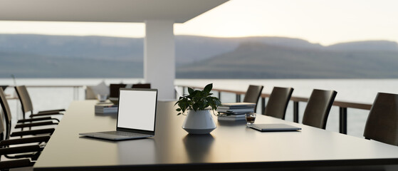 Outdoor meeting table with beautiful nature view, laptop white screen mockup on table