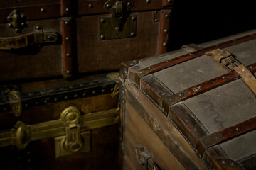 Closeup shot of vintage travel boxes and suitcases with dark background and selective focus.