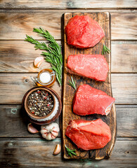 Raw meat. Pieces of fresh beef with spices and herbs .