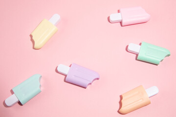 Ice cream toys made from plastic on pink background with copy space
