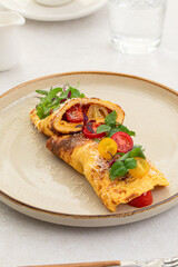 Portion of gourmet omelette with tomatoes, basil and parmesan