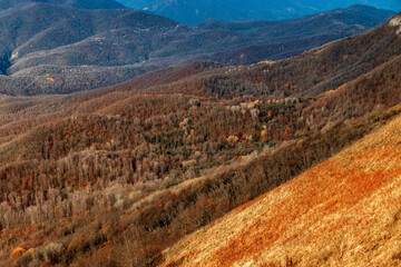 View from a height of 1000 m to the peaks of the Caucasus. Stunning view from the rocky peak of Mount Peus to the mountain peaks of the Caucasus on a sunny day with blue sky and dramatic clouds.