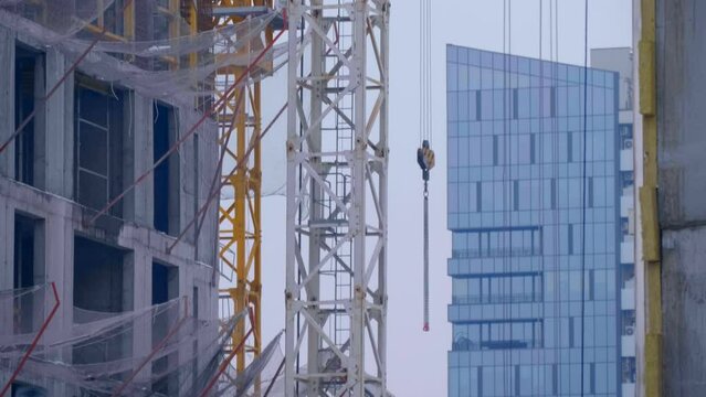 Construction site, where a modern beautiful multi-storey building is being erected by casting a monolith into a formwork reinforced with metal reinforcement. The crane carries the necessary constructi