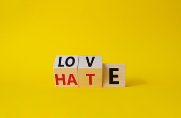 Love vs Hate symbol. Wooden cubes with words Hate and Love. Beautiful yellow background. Valentines...