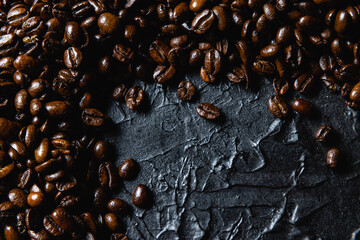 Roasted coffee beans on black design board.
