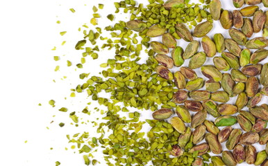 Pistachios chopped and whole peeled pile isolated on white, top view