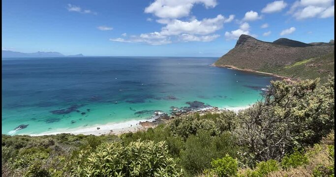Cape Town, South Africa - December 28th, 2022: A panoramic view of Smitswinkel Bay, at the Cape Peninsula. A few fishing ships and boats near the coast.