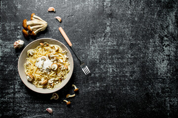 Pasta in bowl with mushrooms and garlic.