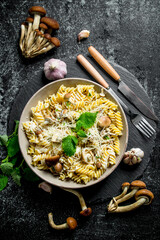 Fusilli pasta in a bowl of mushrooms and garlic.