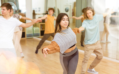 Energetic teens formed pairs and dancing salsa in studio.
