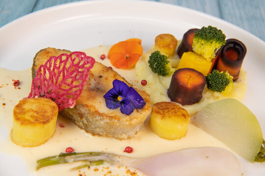 Recipe of cod steak, mashed potatoes and its farandole of vegetables, parsnip, turnip, broccoli, candied potato. High quality photo
