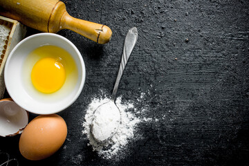 Baking background. Spoon with flour and egg.