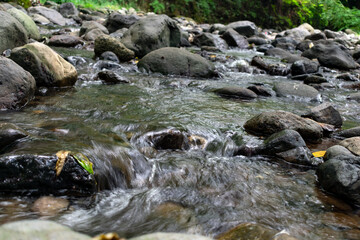 Naklejka na ściany i meble water flowing over rocks