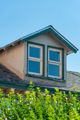 Single house double paned window with visible glass and front or back yard trees with clear blue sky background