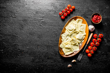 Ravioli with sauce, cherry tomatoes and garlic cloves.