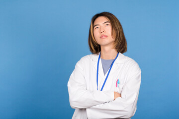 Asian doctor with arms crossed looking up
