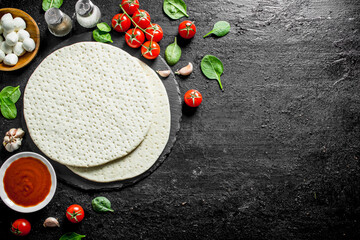 Round pizza dough with mozzarella, tomato paste and spinach.