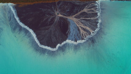 Top down aerial view over natural texture - abstract industrial lake water patterns. Turquoise...