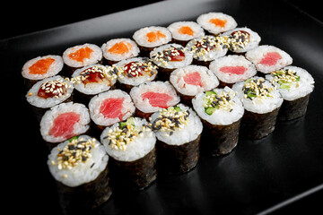 Sushi rolls in assortment on a black background