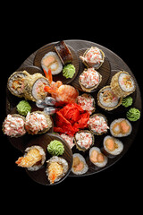 Sushi rolls in assortment on a black background