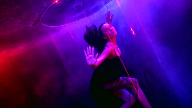 beautiful brunette floating in mysterious pool water or aquarium, fashion photoshoot underwater