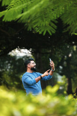 Indian man using smartphone at park.