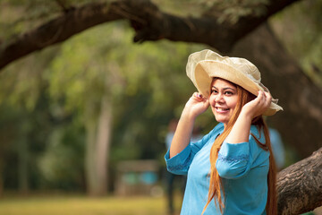 Young indian woman wearing hat and giving expression at park