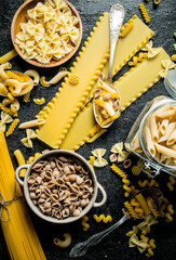 Fototapeta na wymiar Pasta background. Different types of dry pasta in the pot and bowl.