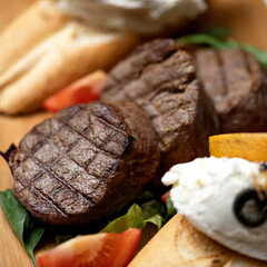 Grilled beef steaks with vegetable garnish. Close-up. Soft focus. High quality photo