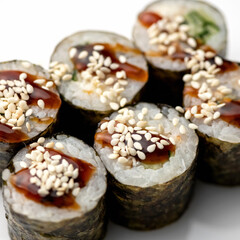 Maki rolls with cucumber sauce and sesame seeds. Close-up. Close-up on white background. Soft focus. Japanese kitchen. 