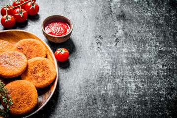 Fish cutlets on a plate with thyme,tomatoes and sauce.