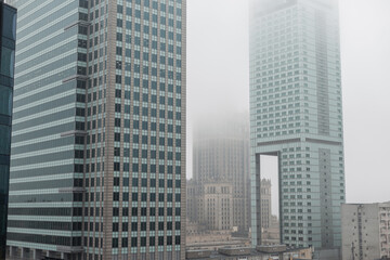 Fototapeta na wymiar Beautiful modern metropolis in the fog with business and office buildings and the Palace of Culture in Warsaw. Amazing city of Warsaw, Poland on a cloudy, overcast day. Urban wallpaper