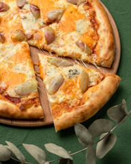 Traditional Italian pizza with pear and gorgonzola cheese. Mediterranean food. Vegetarian dish. Close-up. Green background. Copy space. Top view.