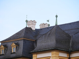 Barocke Schornsteine auf dem Dach eines Schlosses mit Schieferdach