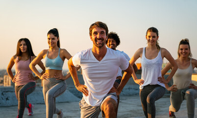 Group of happy fit people friends exercising together outdoor to stay healthy - obrazy, fototapety, plakaty