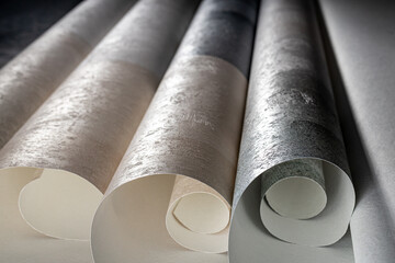 A roll of vinyl wallpaper with a beautiful paper texture in low light