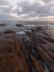 Rocky coastline and cloudy sky at Collaroy, Sydney, Australia.