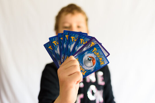 Valencia, Spain - January 10, 2023: A boy holds some Pokemon role playing cards, fashionable among children in schools.