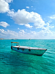 Naklejka na ściany i meble Simple fishing boat in the transparent sea
