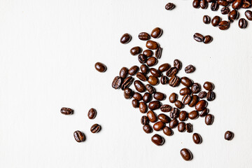 Roasted coffee beans on white leather sheet.