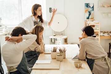 Young women attentively listening to a lecture on ceramics