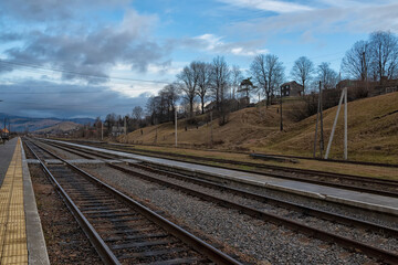 Obraz premium Railway rural station in the mountains. Desert platform of the station. Ukraine. Carpathians. Ivano-Frankivsk region. Yasinya station.