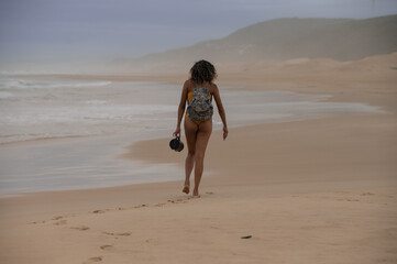 Rear view of woman seen walking along coast