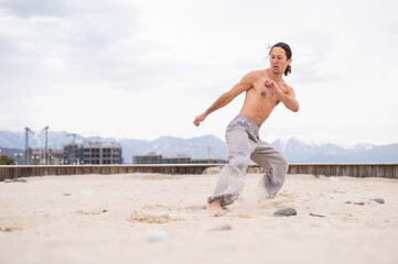 Caucasian man practices martial arts outdoors. balance and meditation.