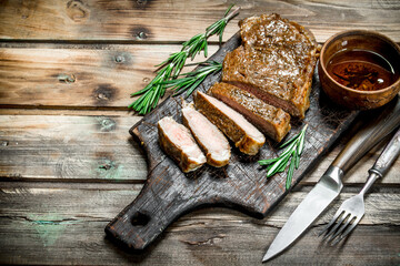 Sliced grilled beef steak with rosemary.