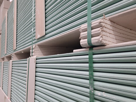 water resistant plasterboard sheets stacked in a hardware store. dry gypsum plaster. building material for the arrangement of cladding, partitions, ceilings in buildings.